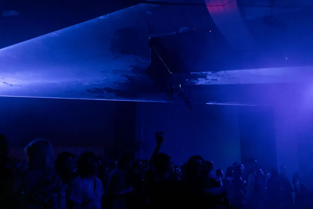 Laser reflections stretching across the room and crowd