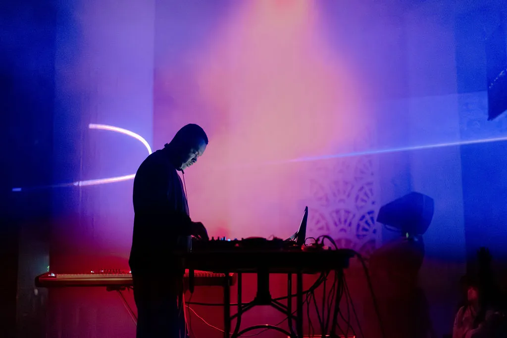 Performer during the set with the laser path carrying the room